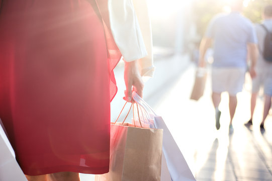 Closeup of woman holding shopping bags on the street with copy space