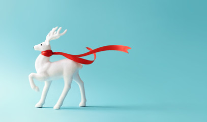 White reindeer with red scarf on pastel blue background. Christmas or New Year minimal concept.