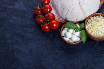 Pizza ingredients on dark stone background