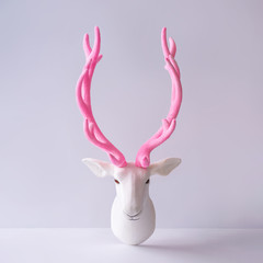 White reindeer with glitter pink antlers. Minimal New Year or Christmas background concept.