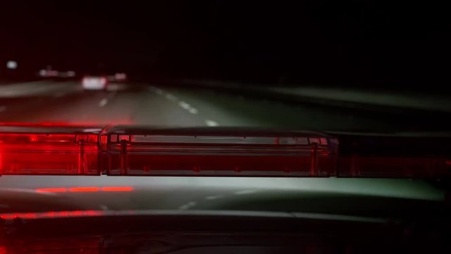 POV Police highway patrol car with red blue flash emergency lights driving