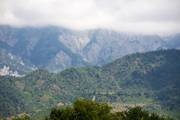 Fototapeta premium Majestic landscape of the mountains and forest in Caucasus at summer. Dramatic sky with clouds.