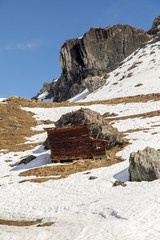 Wooden ruined baita in a snowy scene