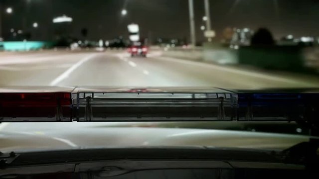 POV Police highway patrol car with red blue flash emergency lights driving