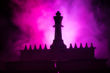 Chess board game concept of business ideas and competition or strategy ideas concept. Chess figures on a dark toned foggy background.