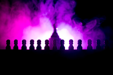 Fototapeta na wymiar Chess board game concept of business ideas and competition or strategy ideas concept. Chess figures on a dark toned foggy background.