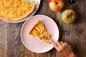 Child hand eating a portion of apple tart