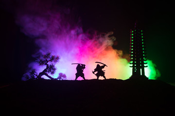 Samurai fighting concept. Silhouette of samurais in duel near tree and old temple. Picture with two samurais and sunset sky. Selective focus