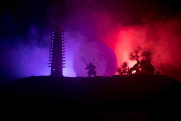 Samurai fighting concept. Silhouette of samurais in duel near tree and old temple. Picture with two...