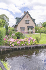 Flowered garden in fron of a traditional dutch house in Giethoorn, Holland