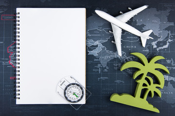 Top view of Blank notebook white paper and passenger plane on world map background with copy space for your message.Business travel transportation system concept.