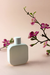 Perfume package with sakura flowers on pastel pink background