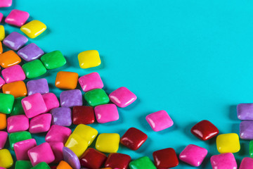 chewing gum of different colors on a blue background