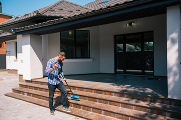Young bearded man makes cleaning the house