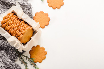 Sweet thin ginger cookies in a gift box on white background on a plaid. Festive pastry. Top view, flat lay.