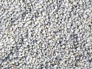 White pebbles background. Beach stones close-up, natural pattern