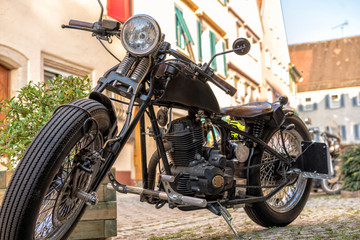 Fototapeta na wymiar Altes Motorrad steht in Gasse der Altstadt 