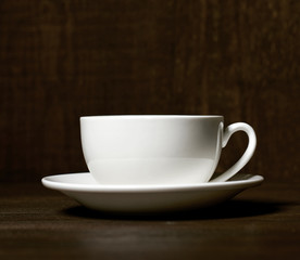 Obraz na płótnie Canvas one classic coffee or tea cup on a dark wooden background