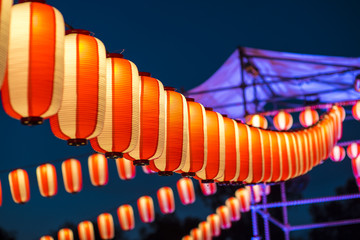 Orange paper lanterns strung in a line on festival