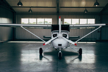 modern small airplane standing in hangar - obrazy, fototapety, plakaty