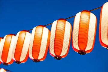 Orange paper lanterns strung in a line on festival