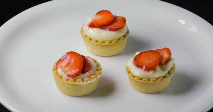 Pasticcini freschi con crema pasticciera bianca e fragole rosse.