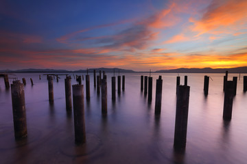 Abandoned concrete pillars on the sea in the beautiful sunrise 
