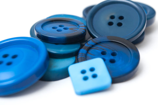 closeup of blue sewing buttons on white background