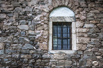 Fototapeta na wymiar wall of the old stone house with window for your design