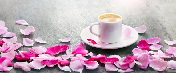 Fototapeta na wymiar Coffee cup and pink roses petals pattern. Flat lay, top view