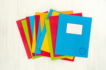 Colored exercise books on wooden table