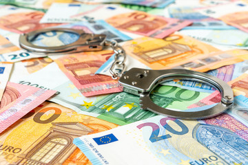 Euro banknotes and metal handcuffs