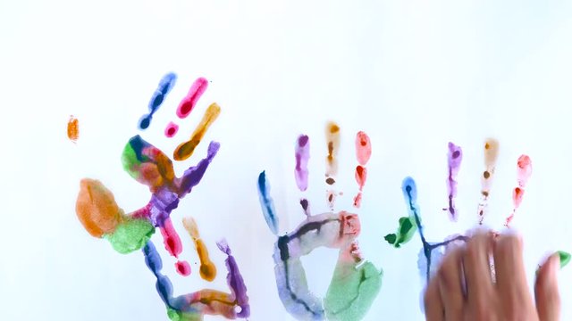 Creative concept - man and woman make prints of their painted hands on a white background