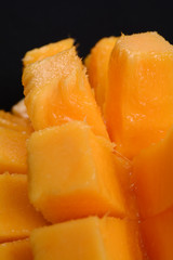 Ripe cut mango on black background