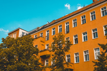 Fototapeta na wymiar orange apartment building with darken sky in vintage colors