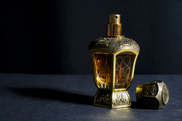 Arab perfume in a bottle, isolated in black background, in low light condition