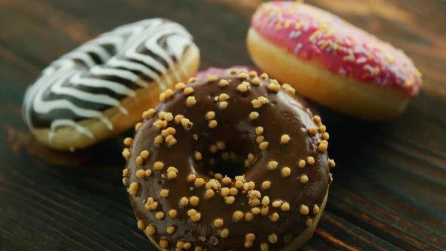 From above sweet tasty donuts with different glazing on wooden table 