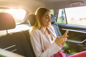 Woman with smart phone in a car
