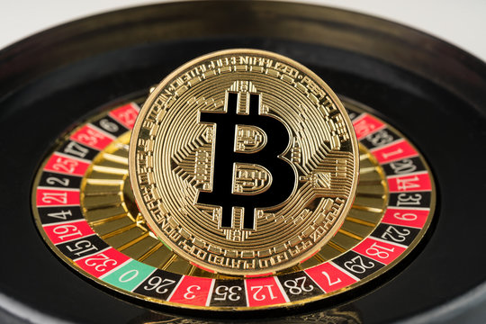 Gold physical Bitcoin coin on casino roulette. Crypto currency market gambling abstract concept.