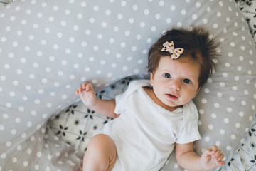 Portrait of adorable baby girl lying ion a nursing pillow