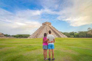 Young couple enjoying the amazing Kukulkan pyramid in Chichen Itza, Mexico