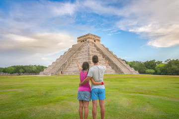 Young couple enjoying the amazing Kukulkan pyramid in Chichen Itza, Mexico