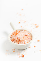 Healthy food concept pink Himalayan salt in white ceramic cup on white background