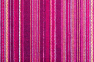 Striped fabric texture with multiple warm colors (purple, purple, magenta, pink, red, maroon,...