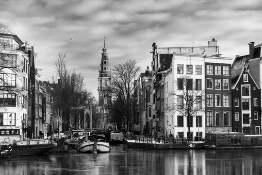 Beautiful view of the river Amstel and the Groenburgwal with the Zuiderkerk (Southern Church) in Amsterdam, the Netherlands, in black and white. 