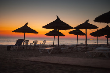 Tropical Beach with Straw Sun Umbrellas