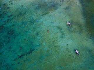 Kayak and boats on crystal clear water of Koh Phi Phi, Thailand - Drone Photography