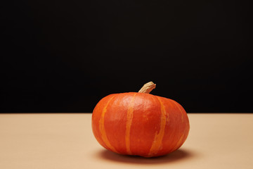 one orange pumpkin on beige table