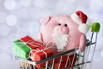 .The symbol of the year 2019 is a pig with gifts in a shopping trolley close-up.