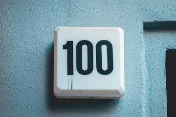 number 100 door sign on cold background